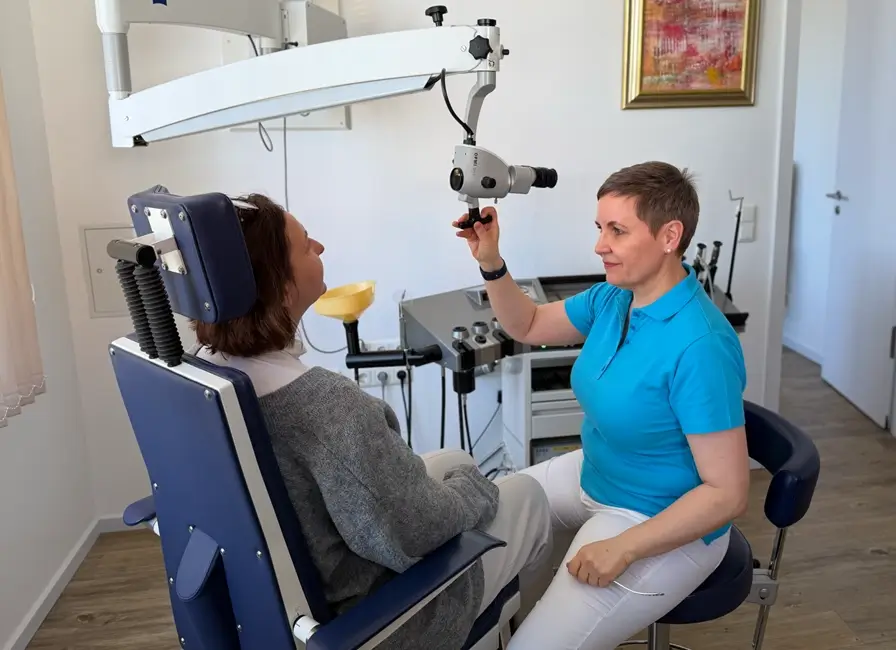 HNO-Ärztin Maren Festner stellt das hochentwickelte Untersuchungsmikroskop für die Behandlung einer Patientin ein.