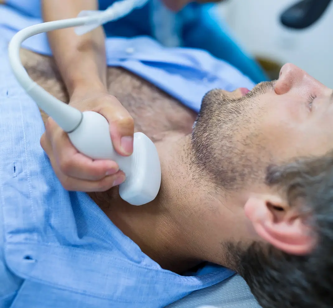 Eine HNO-Untersuchung mittels Ultraschall (Sonographie) der Halsweichteile und Lymphknoten bei einem männlichen Patienten.